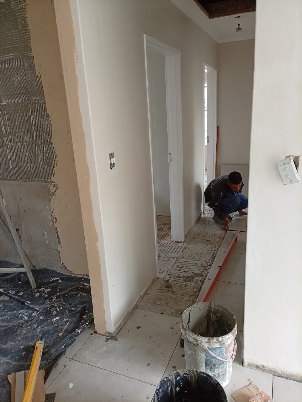 Floor tiles laid through a hallway, doorways opening onto two rooms